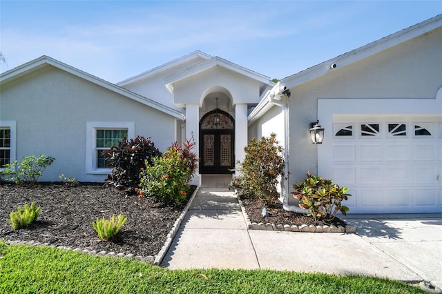 3238 Cullendale Dr, Tampa, FL 33618 - property entrance with an attached garage, stucco siding, and french doors