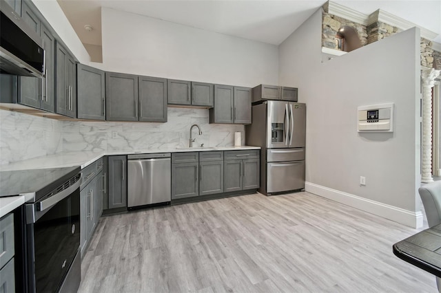 3238 Cullendale Dr, Tampa, FL 33618 - kitchen with baseboards, a sink, light wood finished floors, appliances with stainless steel finishes, and backsplash