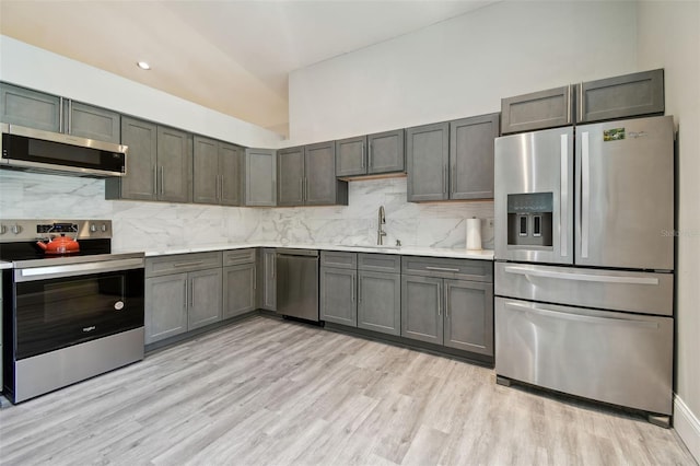 3238 Cullendale Dr, Tampa, FL 33618 - kitchen featuring appliances with stainless steel finishes, a sink, light wood finished floors, light countertops, and decorative backsplash