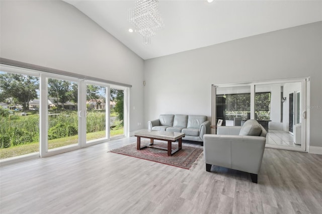 3238 Cullendale Dr, Tampa, FL 33618 - living room featuring high vaulted ceiling, baseboards, wood finished floors, and a notable chandelier