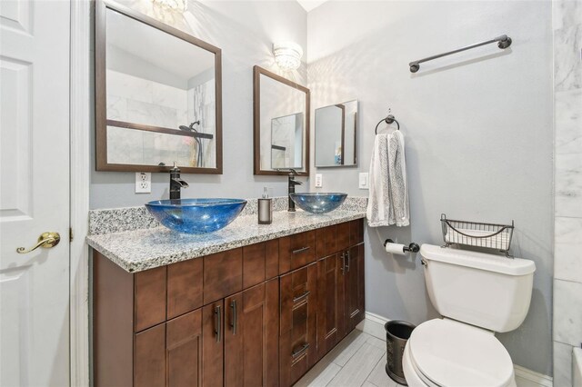3238 Cullendale Dr, Tampa, FL 33618 - bathroom featuring a sink, baseboards, toilet, and double vanity