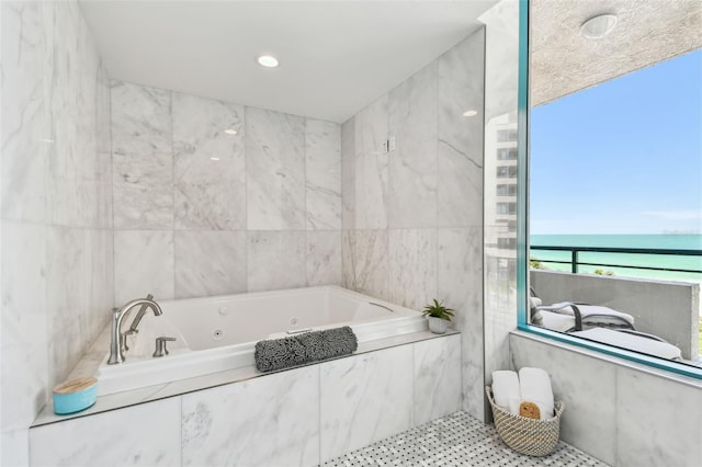 bathroom with a water view, tile walls, and a jetted tub