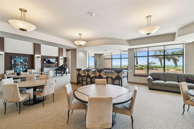 dining room with baseboards and light carpet