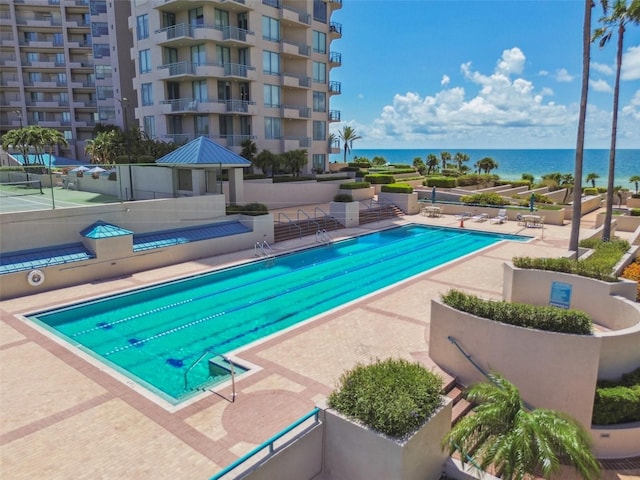 community pool featuring a patio, a gazebo, fence, and a water view