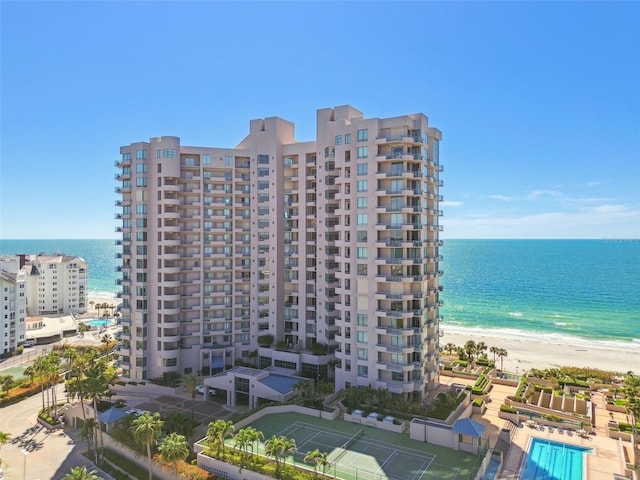 view of building exterior with a water view and a view of the beach