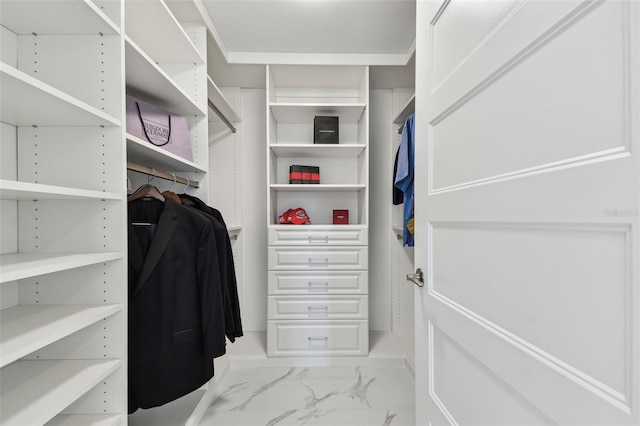 walk in closet featuring marble finish floor