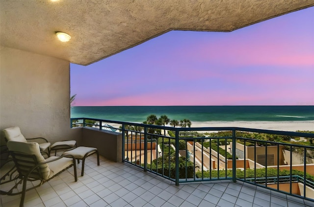 balcony featuring a water view and a view of the beach