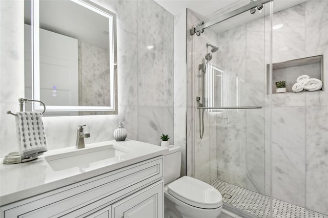bathroom with vanity, a marble finish shower, and toilet