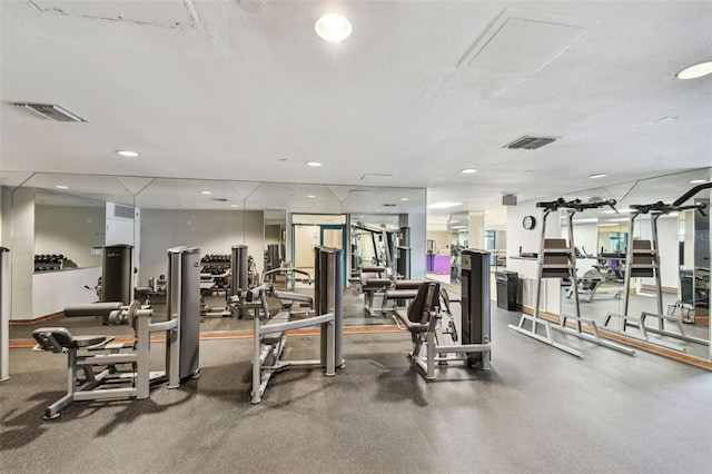exercise room featuring recessed lighting, a textured ceiling, and visible vents