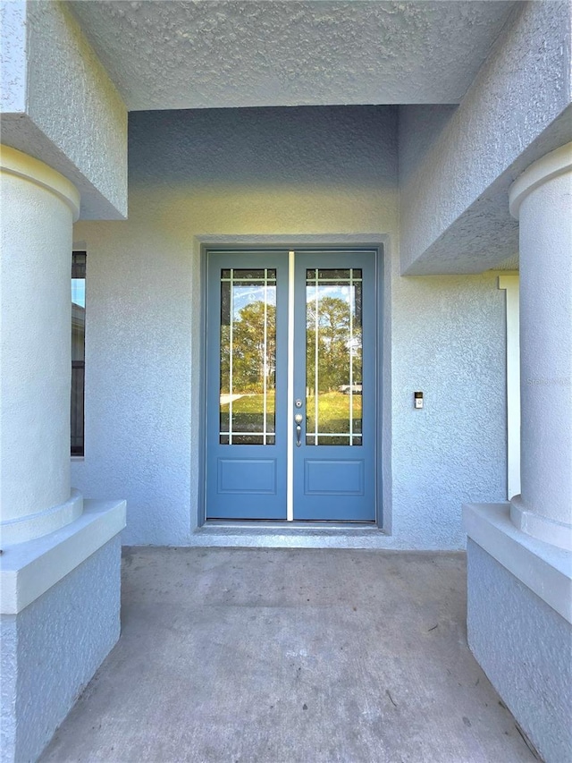 11240 Marvelwood, Brooksville, FL 34614 - view of exterior entry featuring a patio, stucco siding, and french doors