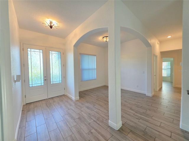 11240 Marvelwood, Brooksville, FL 34614 - foyer with wood tiled floor, arched walkways, french doors, and baseboards
