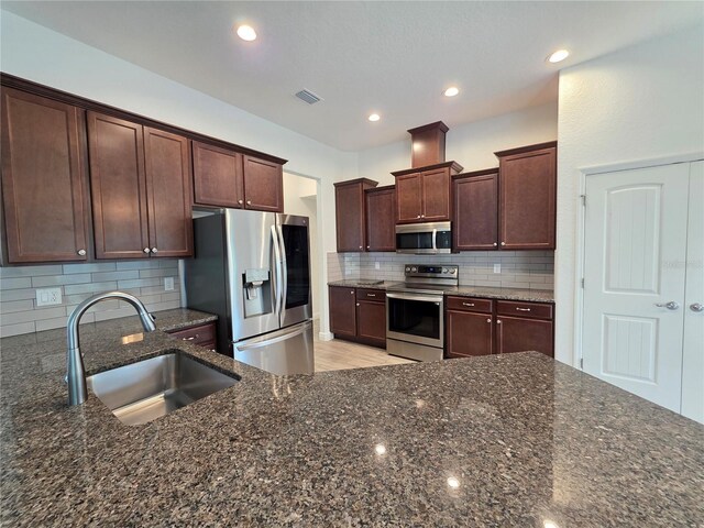 11240 Marvelwood, Brooksville, FL 34614 - kitchen featuring decorative backsplash, dark stone countertops, appliances with stainless steel finishes, and a sink