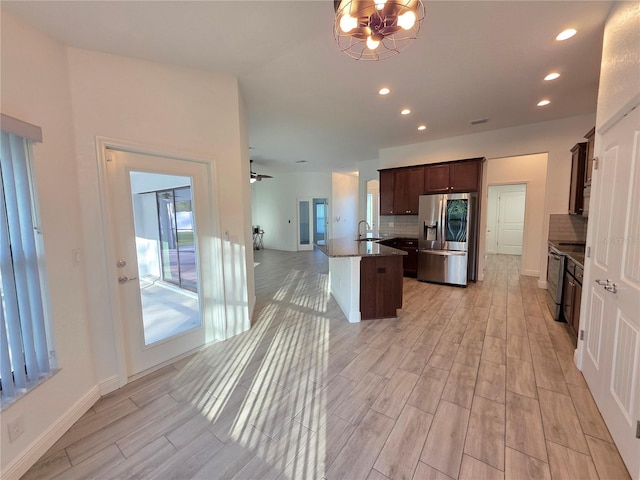 11240 Marvelwood, Brooksville, FL 34614 - kitchen with light wood finished floors, a sink, open floor plan, stainless steel fridge with ice dispenser, and decorative backsplash