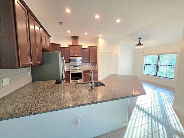 11240 Marvelwood, Brooksville, FL 34614 - kitchen with a sink, a peninsula, visible vents, backsplash, and appliances with stainless steel finishes