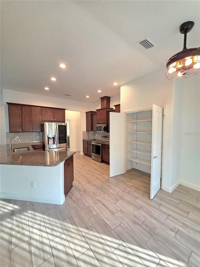11240 Marvelwood, Brooksville, FL 34614 - kitchen with a sink, stainless steel appliances, tasteful backsplash, dark stone countertops, and visible vents