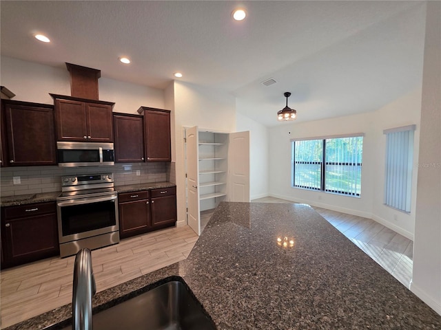 11240 Marvelwood, Brooksville, FL 34614 - kitchen featuring dark brown cabinets, dark stone countertops, backsplash, appliances with stainless steel finishes, and lofted ceiling