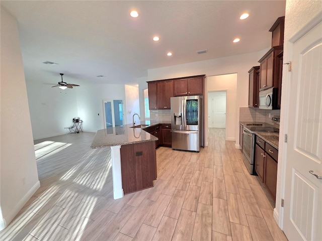 11240 Marvelwood, Brooksville, FL 34614 - kitchen with a peninsula, appliances with stainless steel finishes, stone counters, and backsplash