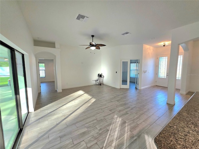 11240 Marvelwood, Brooksville, FL 34614 - unfurnished living room with wood tiled floor, visible vents, a ceiling fan, and arched walkways