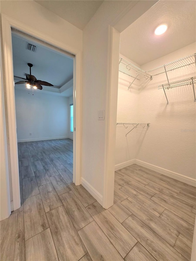 11240 Marvelwood, Brooksville, FL 34614 - walk in closet featuring a ceiling fan, visible vents, and wood finished floors