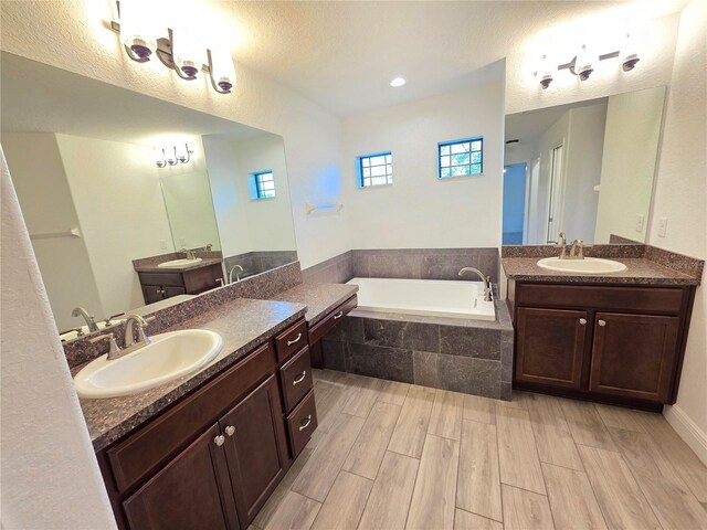 11240 Marvelwood, Brooksville, FL 34614 - bathroom featuring a garden tub, a sink, and wood finished floors