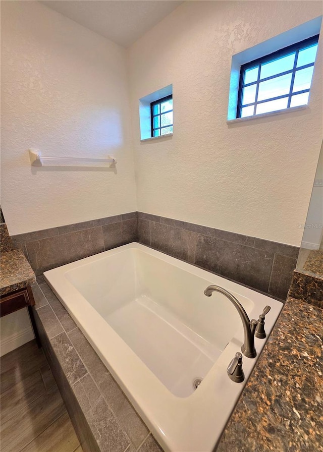 11240 Marvelwood, Brooksville, FL 34614 - bathroom featuring a bath, wood finished floors, vanity, and a healthy amount of sunlight