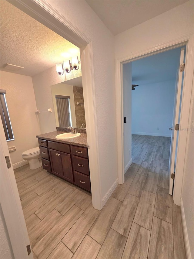 11240 Marvelwood, Brooksville, FL 34614 - full bath featuring toilet, baseboards, wood finished floors, and vanity