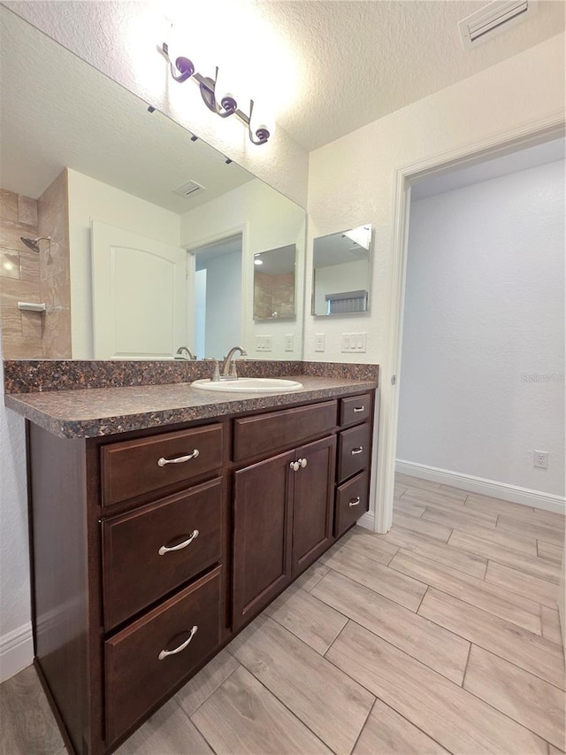 11240 Marvelwood, Brooksville, FL 34614 - full bath with wood tiled floor, a textured ceiling, visible vents, and vanity