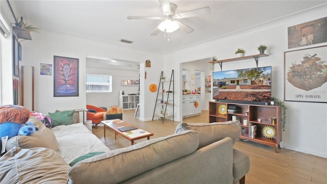 6325 9th Ave S, Gulfport, FL 33707 - living room featuring a ceiling fan, wood finished floors, and baseboards