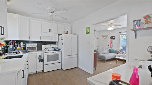 6325 9th Ave S, Gulfport, FL 33707 - kitchen with white appliances, a ceiling fan, light wood finished floors, and a sink