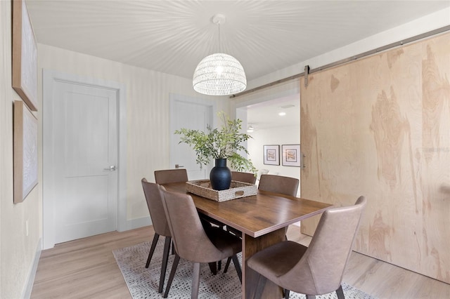 1443 Paloma Ln, Dunedin, FL 34698 - dining room with a barn door, baseboards, light wood-style floors, and a chandelier