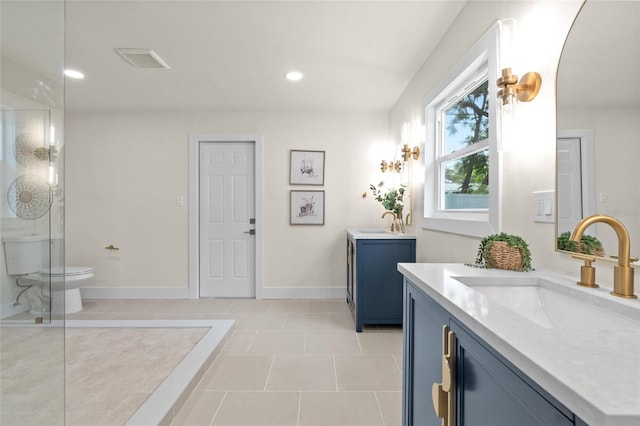 1443 Paloma Ln, Dunedin, FL 34698 - bathroom with two vanities, toilet, recessed lighting, baseboards, and tile patterned flooring