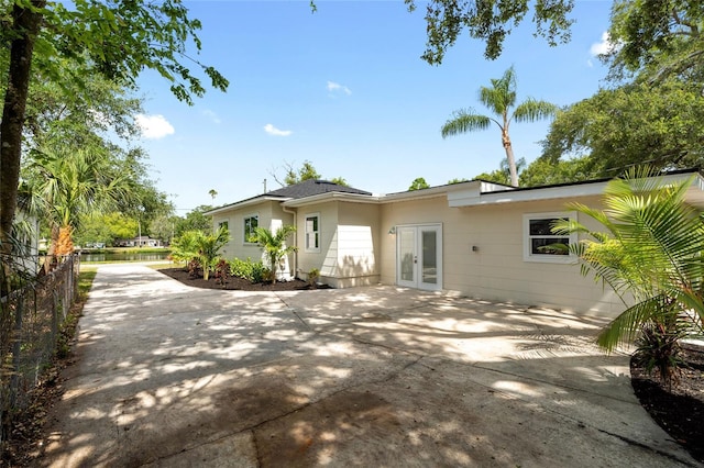 1443 Paloma Ln, Dunedin, FL 34698 - back of house featuring french doors, fence, a patio area, and concrete driveway