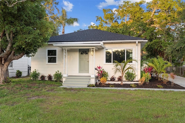 1443 Paloma Ln, Dunedin, FL 34698 - bungalow-style house with a front lawn and a shingled roof