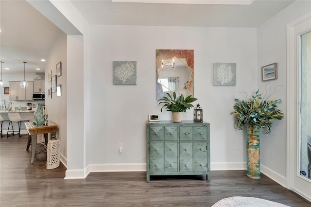 corridor featuring recessed lighting, baseboards, dark wood-style floors, and plenty of natural light