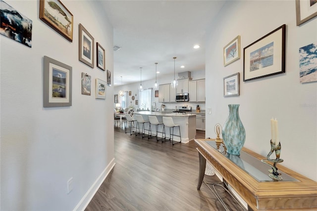 corridor with recessed lighting, dark wood finished floors, and baseboards