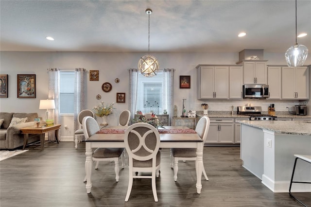 dining space featuring baseboards, dark wood-style floors, and a wealth of natural light