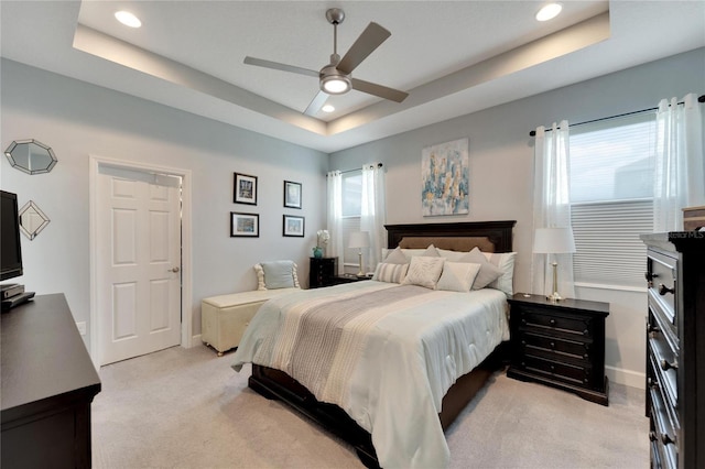 bedroom featuring baseboards, light carpet, a tray ceiling, and recessed lighting