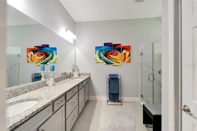 full bathroom featuring double vanity, tile patterned floors, a marble finish shower, and a sink