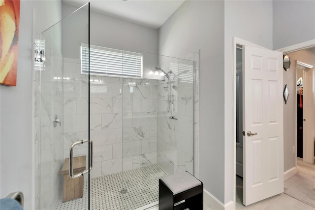 full bath featuring tile patterned floors, baseboards, and a shower stall
