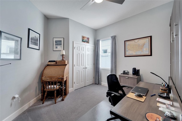 office featuring light colored carpet, a ceiling fan, and baseboards