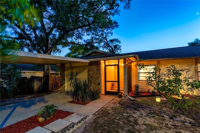 view of outbuilding with fence, driveway, and an attached carport