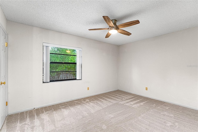 carpeted spare room with a textured ceiling, ceiling fan, and baseboards