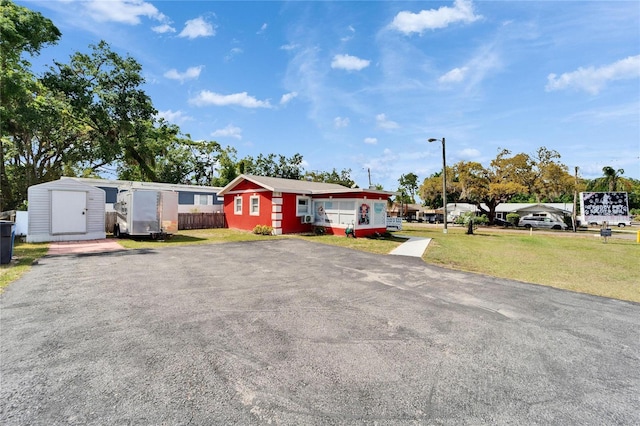 126 Ridgewood Ave, Brandon, FL 33510 - view of front of property with an outdoor structure, fence, a front yard, and a shed