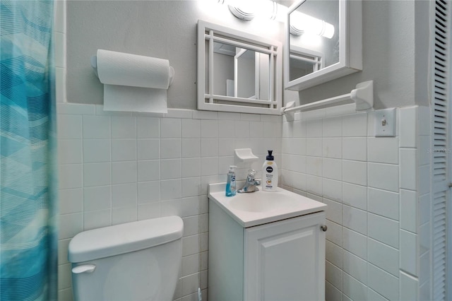 126 Ridgewood Ave, Brandon, FL 33510 - bathroom featuring tile walls, toilet, wainscoting, a shower with shower curtain, and vanity