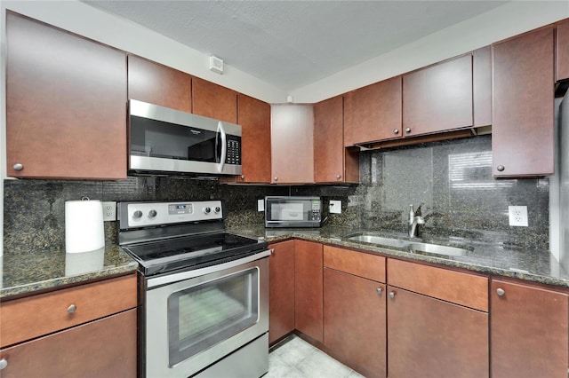 126 Ridgewood Ave, Brandon, FL 33510 - kitchen with dark stone countertops, appliances with stainless steel finishes, decorative backsplash, and a sink