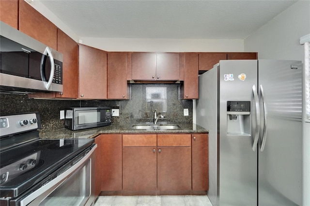 126 Ridgewood Ave, Brandon, FL 33510 - kitchen featuring dark stone countertops, appliances with stainless steel finishes, tasteful backsplash, and a sink