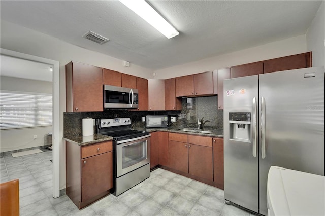 126 Ridgewood Ave, Brandon, FL 33510 - kitchen with a sink, stainless steel appliances, dark stone countertops, visible vents, and decorative backsplash