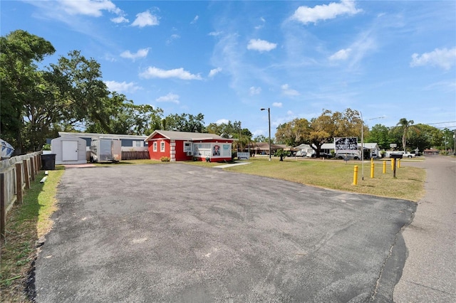 126 Ridgewood Ave, Brandon, FL 33510 - view of front of home with fence, a front yard, a shed, an outbuilding, and driveway