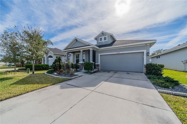 5538 Spanish Moss Cv, Bradenton, FL 34203 - view of front of home featuring a front lawn, stone siding, an attached garage, concrete driveway, and stucco siding