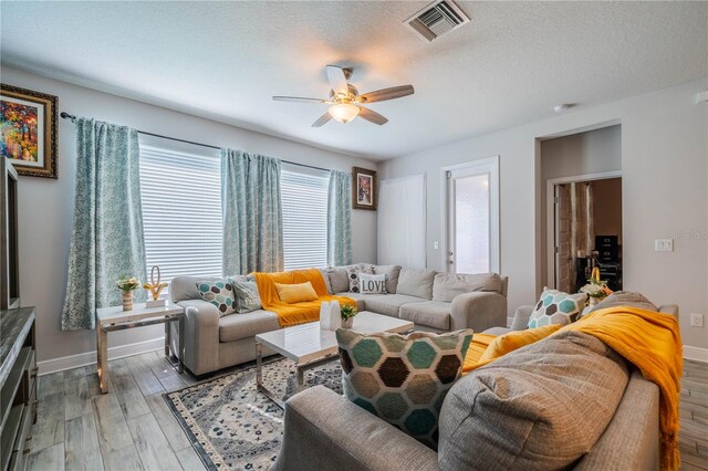 5538 Spanish Moss Cv, Bradenton, FL 34203 - living area featuring light wood-style floors, ceiling fan, baseboards, and a textured ceiling
